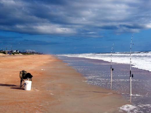 Unrecognizable fisherman choosing fishing lures on seashore - a